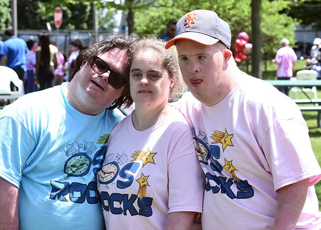 Three people posing for a picture at an outdoor event